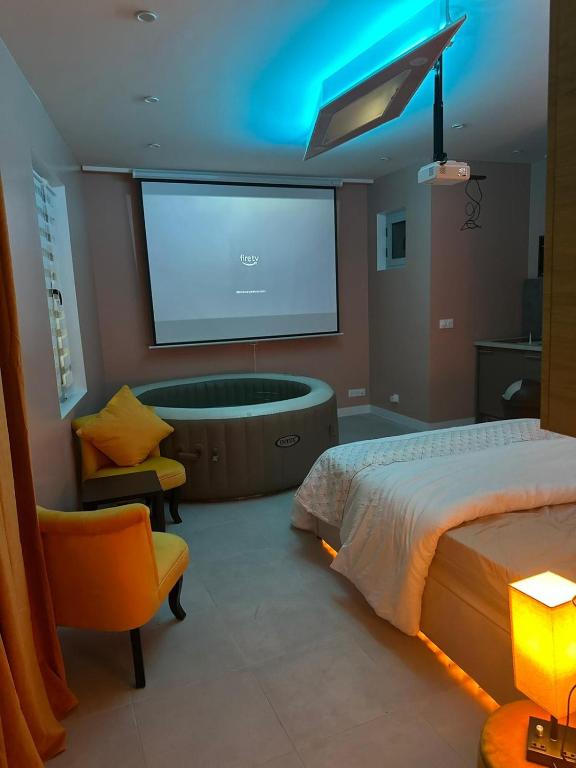 a bedroom with a bed and a tv and a tub at Crownn - Spa Privatif in Fontenay-sous-Bois