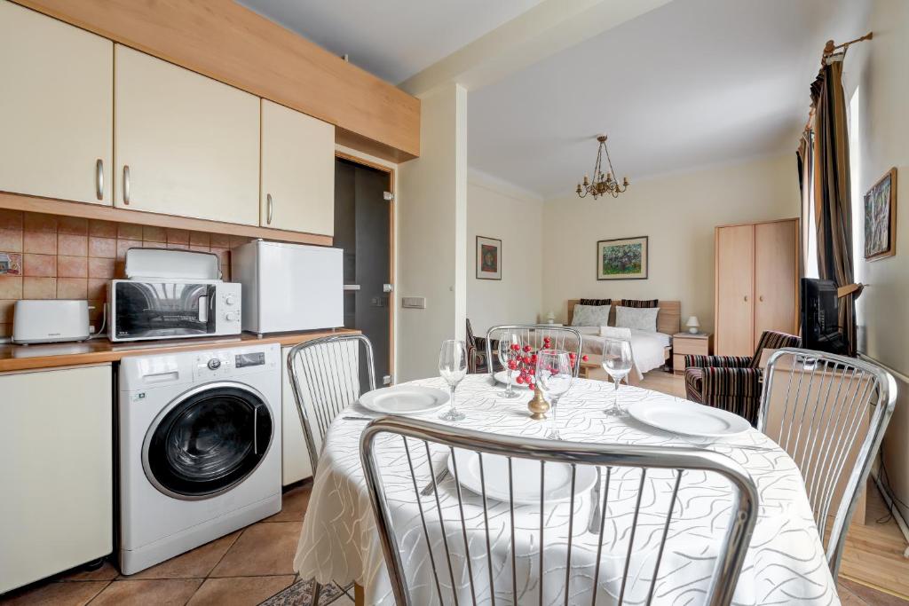 a kitchen and dining room with a table with chairs and a washing machine at Old Town Apartment Antokolskio in Vilnius