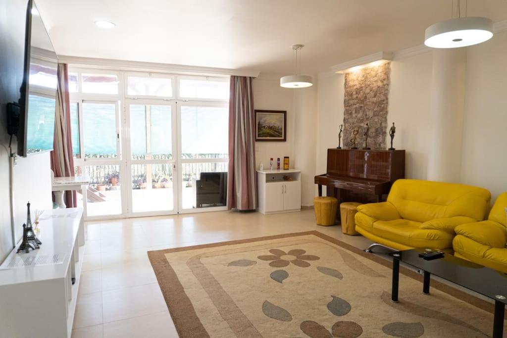 a living room with a yellow couch and a table at Casa Moderna cerca de la PLAYA in Castellón de la Plana