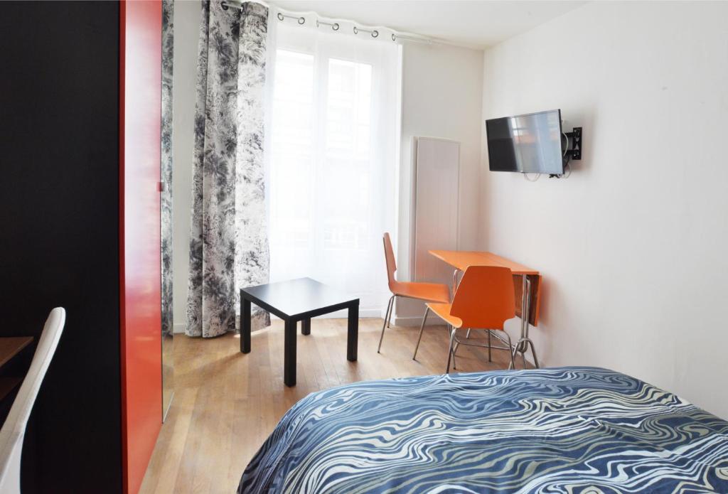 a bedroom with a bed and a table and a desk at Chez Alycelia - Studio - Orly - Gare - 25' Paris centre in Juvisy-sur-Orge