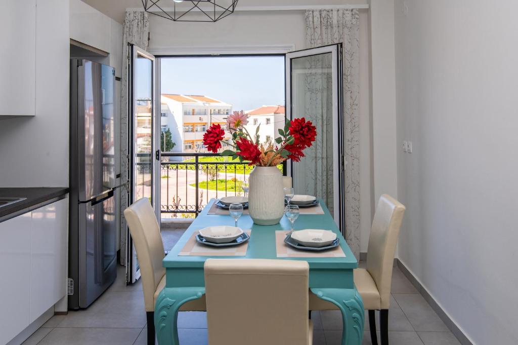 a dining room with a blue table and chairs and a balcony at Karlovasi Comfy Retreat in Ríva