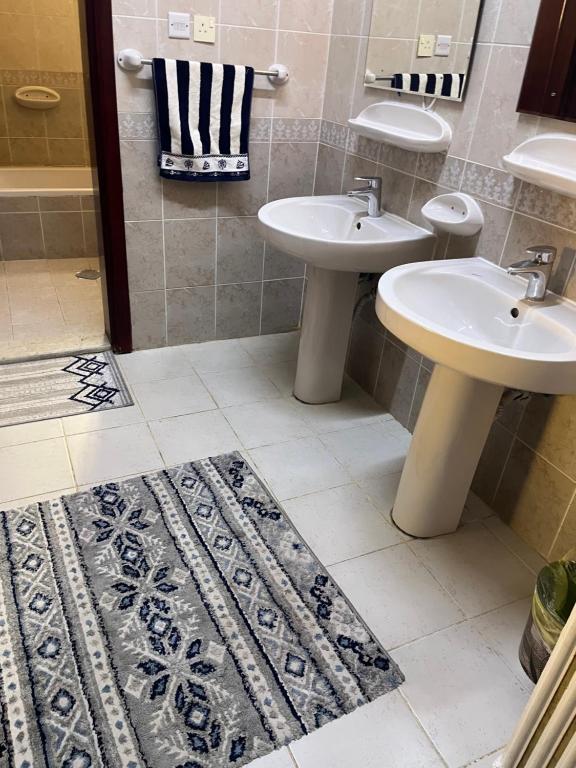 a bathroom with two sinks and a rug at شقة فندقية in Al Madinah