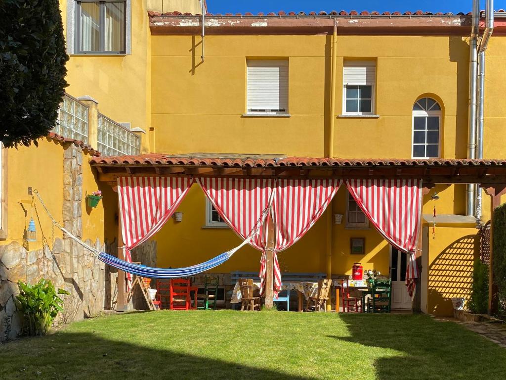 a patio with a red and white tent in a yard at El Jardín de la Morena by ARoom in León
