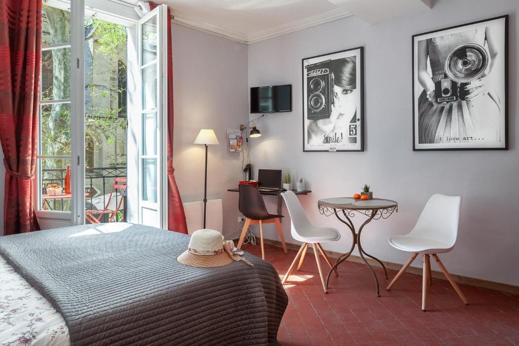 um quarto com uma cama, uma mesa e cadeiras em Centre Palais des Papes-Balcon B1 Clim - 123avignon em Avignon
