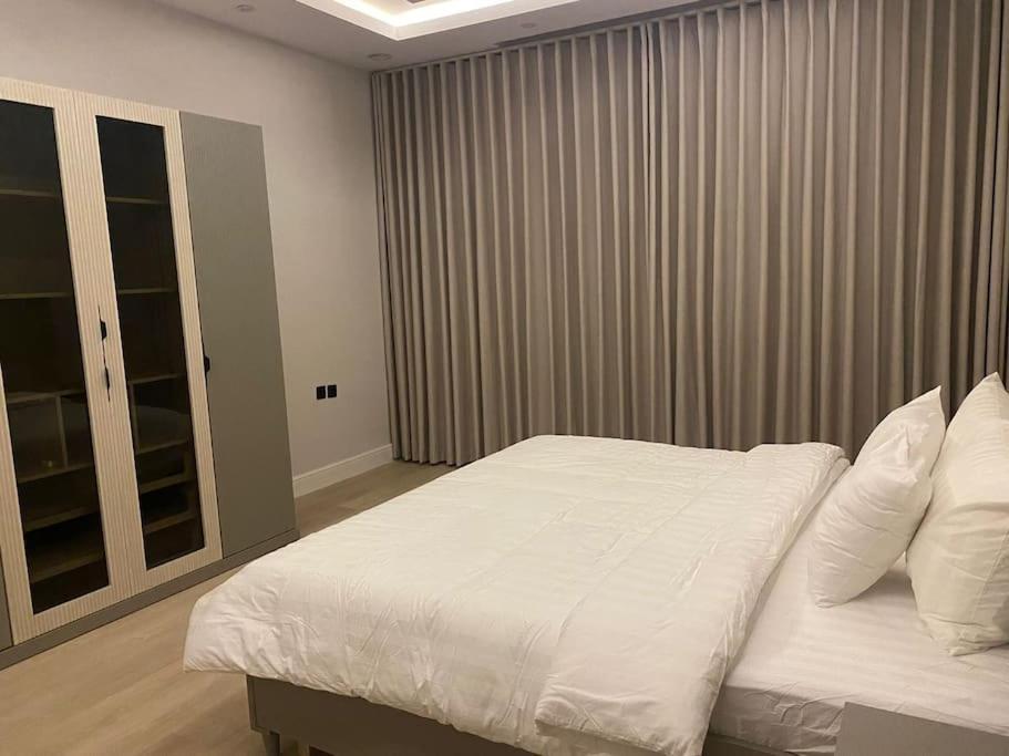 a bedroom with a large bed with white sheets and pillows at شقة مريحة بتصميم انيق ودخول ذكي in Riyadh