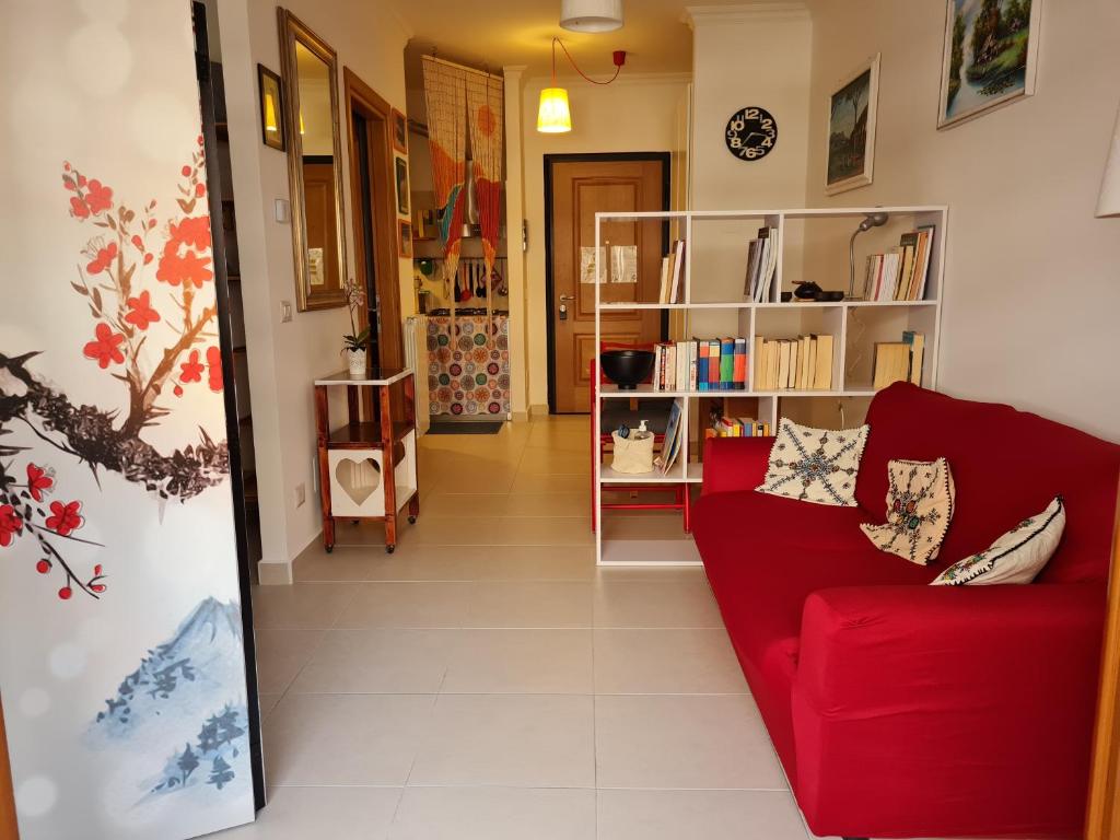 salon z czerwoną kanapą i półką na książki w obiekcie Cozy studio flat in Rome w Rzymie