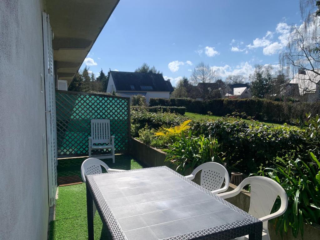 d'une table et de chaises sur un balcon avec un jardin. dans l'établissement DINAPARK, à Dinard