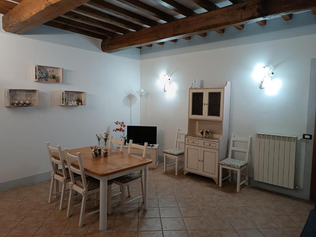 a dining room with a table and chairs and a television at Shabby House in Podere Modello