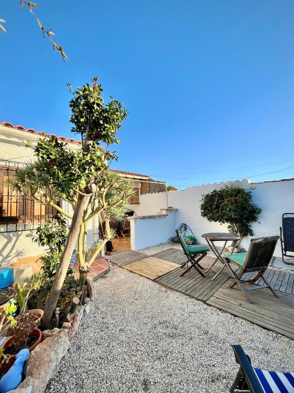 a patio with two chairs and a table on a house at Bungalow Steps from Moraira in Teulada