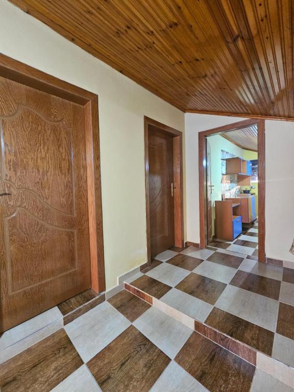 a room with a wooden door and a checkerboard floor at Castle - inside,Voga Guesthause in Krujë