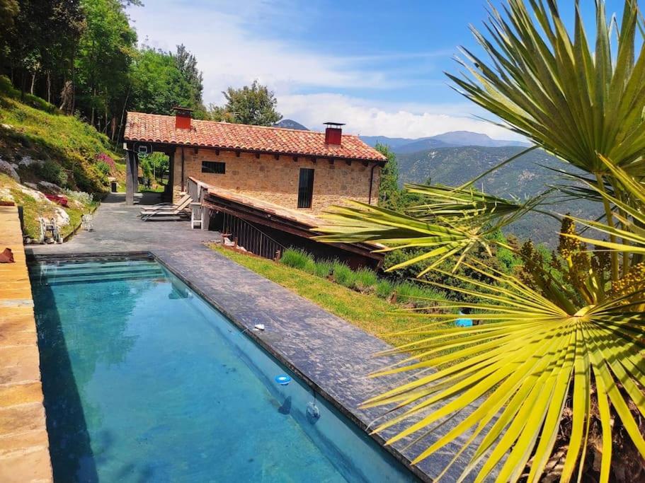 a house with a swimming pool next to a building at Masía La Garrotxa in Olot