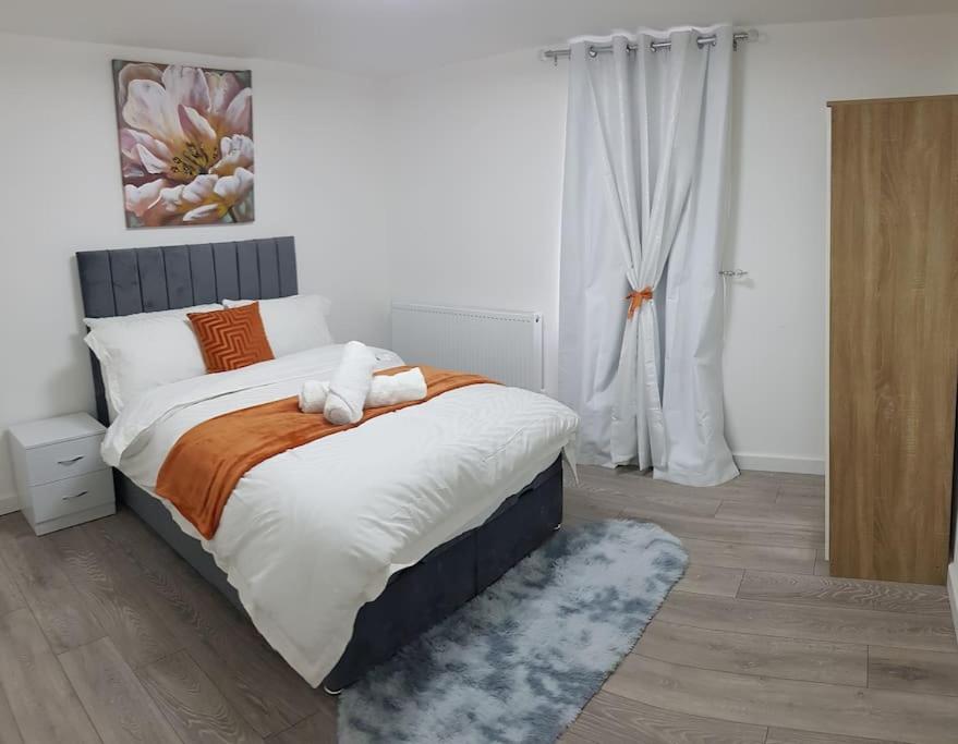 a bedroom with a large bed with orange and white pillows at Holiday Let - Entire modern home in Medway in Gillingham
