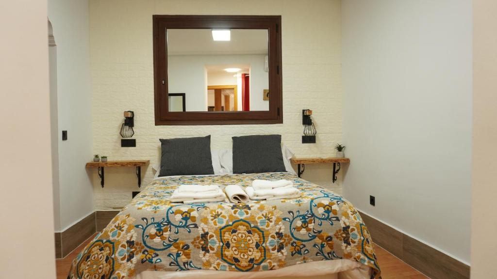 - une chambre avec un lit et un miroir mural dans l'établissement Real, à Tolède