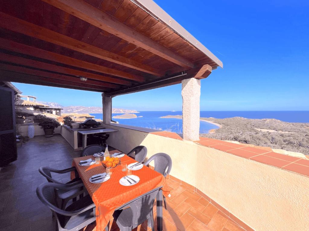 un tavolo su un balcone con vista sull'oceano di PUNTA EST QUADRILOCALE TERRAZZA FAVOLOSA VISTA MARE a Capo Coda Cavallo