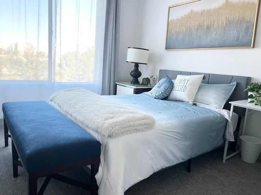 een slaapkamer met een bed met een blauwe deken en een raam bij In the heart of Vegas luxury 2B2B sleeps 6 in Las Vegas