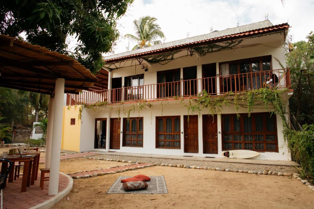 a house with a balcony and a patio at Casa Triz in Puerto Escondido