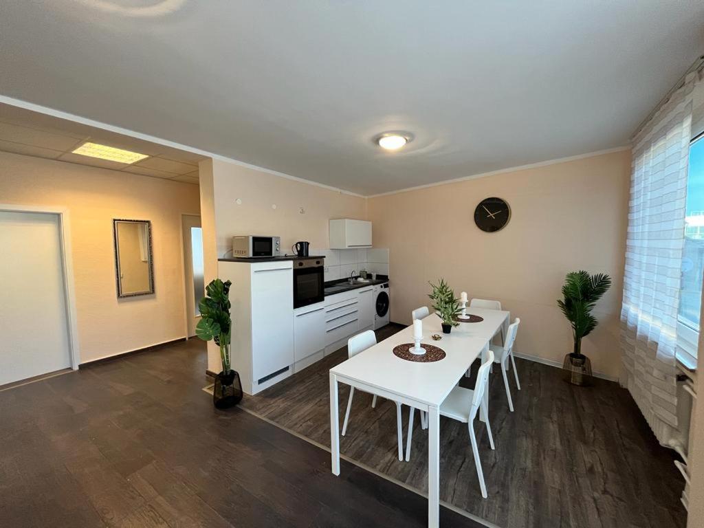 a living room with a white table and a kitchen at Eterna Comfort Living in Essen