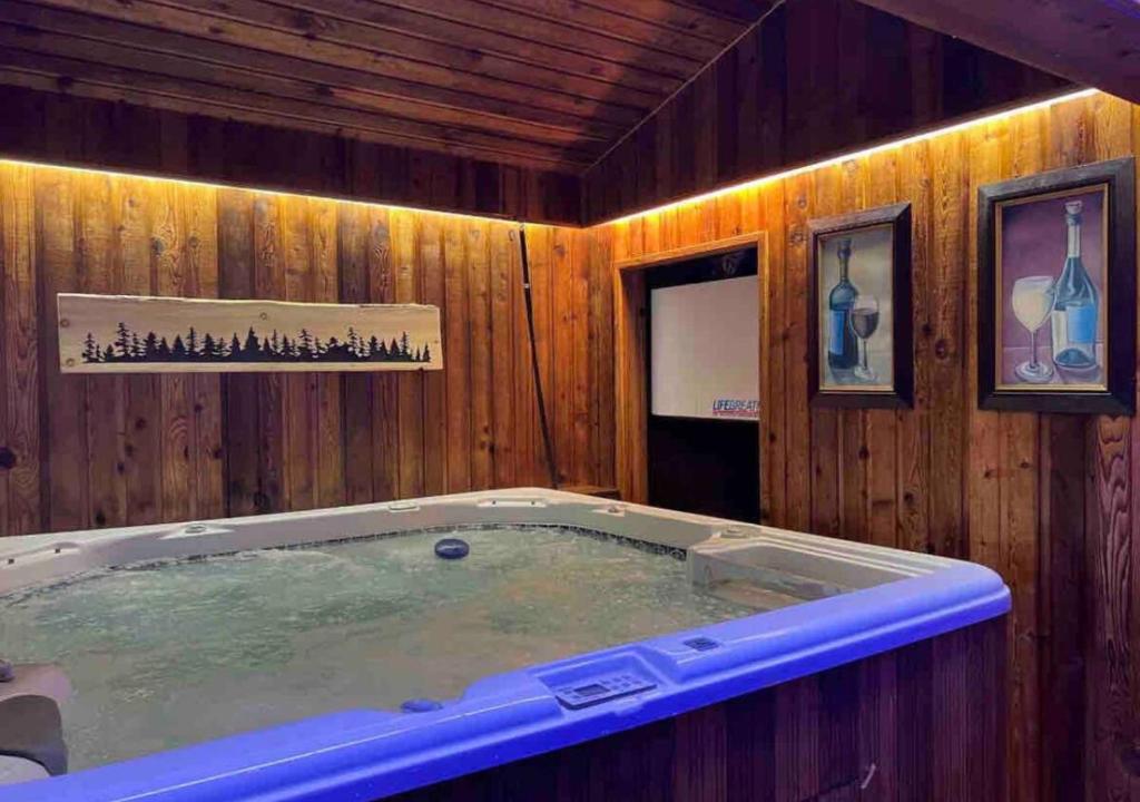 a jacuzzi tub in a room with wooden walls at Oceanside Manor (Beach View) in Qualicum Beach