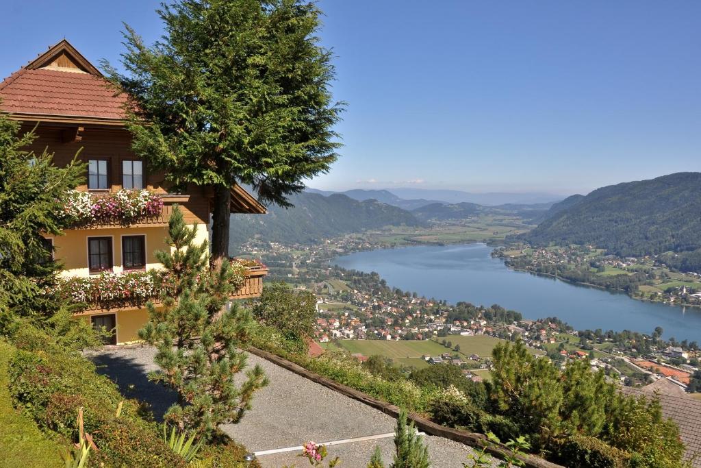 a house on a hill with a view of a river at Mathiasl Panorama Ferienwohnungen in Bodensdorf