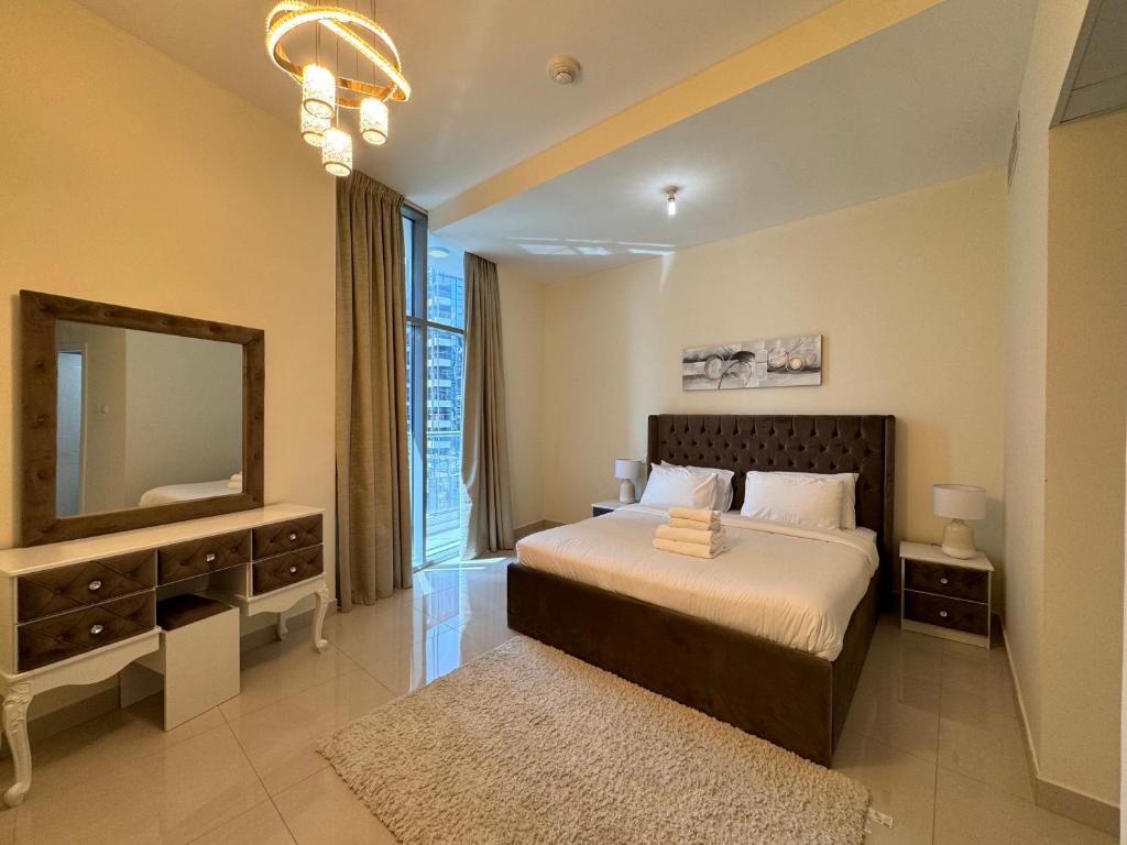 een slaapkamer met een bed met een spiegel en een televisie bij Luxury apartment 3 beds Marina view in Dubai