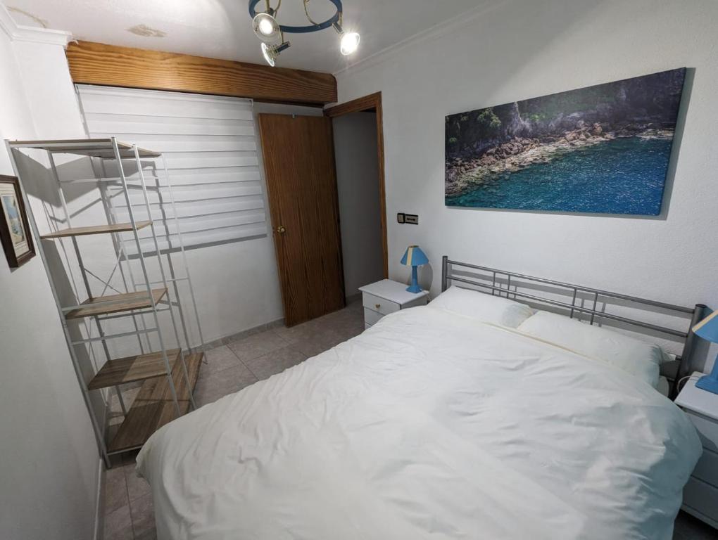 a bedroom with a white bed and a ladder at Casa Plaza Relleu in Relleu