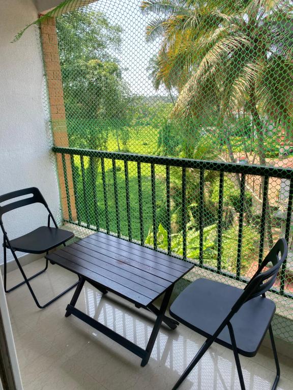a table and two chairs on a balcony with a view at Luxury apartment Blue lagoon in Goa