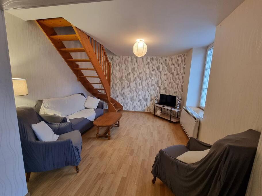 ein Wohnzimmer mit einer Treppe und einer Couch in der Unterkunft L Essentiel Appartement accueillant 5 pers 