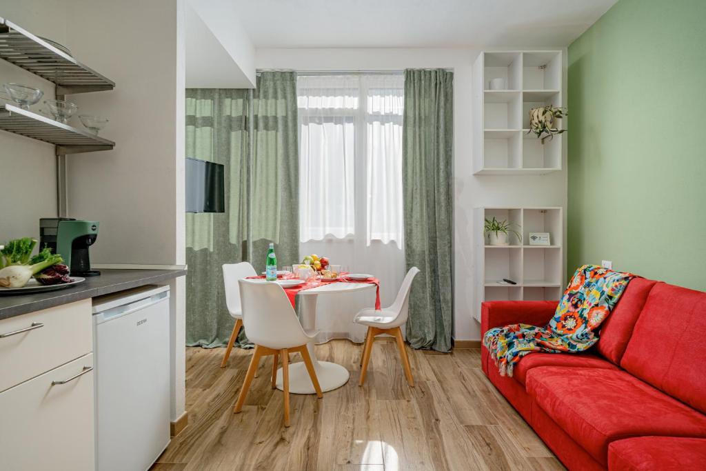 a living room with a red couch and a table at Residenze Asproni Serviced Apartments in Cagliari