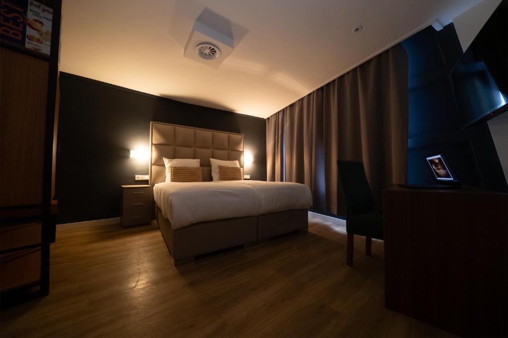 een hotelkamer met een bed, een bureau en een stoel bij MA Airport Hotel in Hoofddorp
