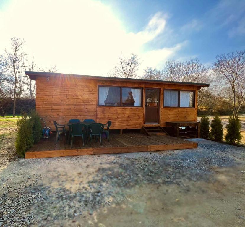 una casa pequeña con terraza y sillas en Лятна каравана “Айтата”, en Kiten