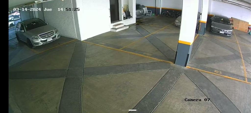 un garaje con dos coches aparcados en él en Departamento Céntrico CDMX, en Ciudad de México