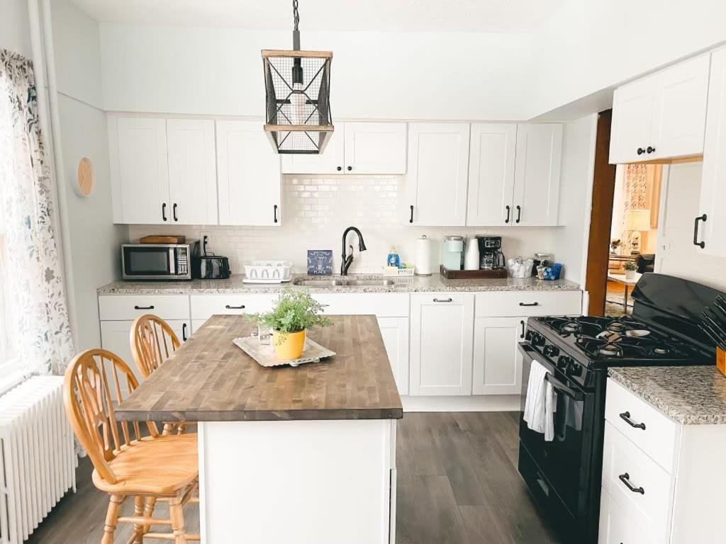 a kitchen with white cabinets and a wooden table at 4BR 2BA Home in Charming St Paul - Sleeps 10 in Saint Paul