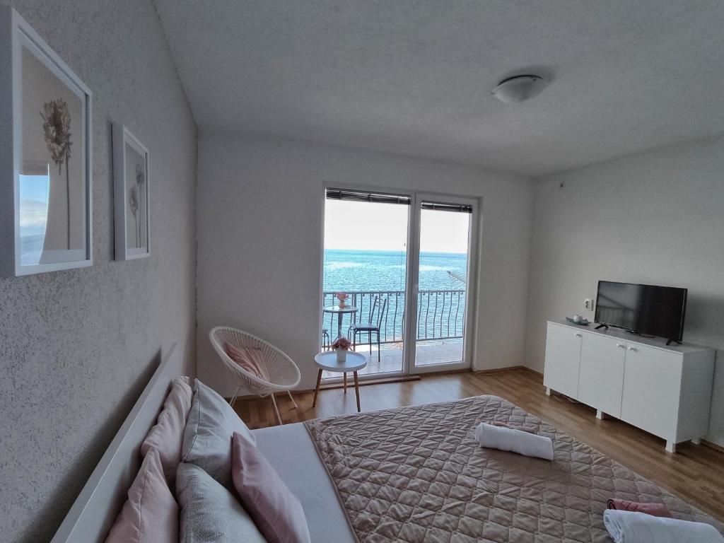 um quarto com uma cama e vista para o oceano em Apartment Polkaposki Trpejca em Trpejca