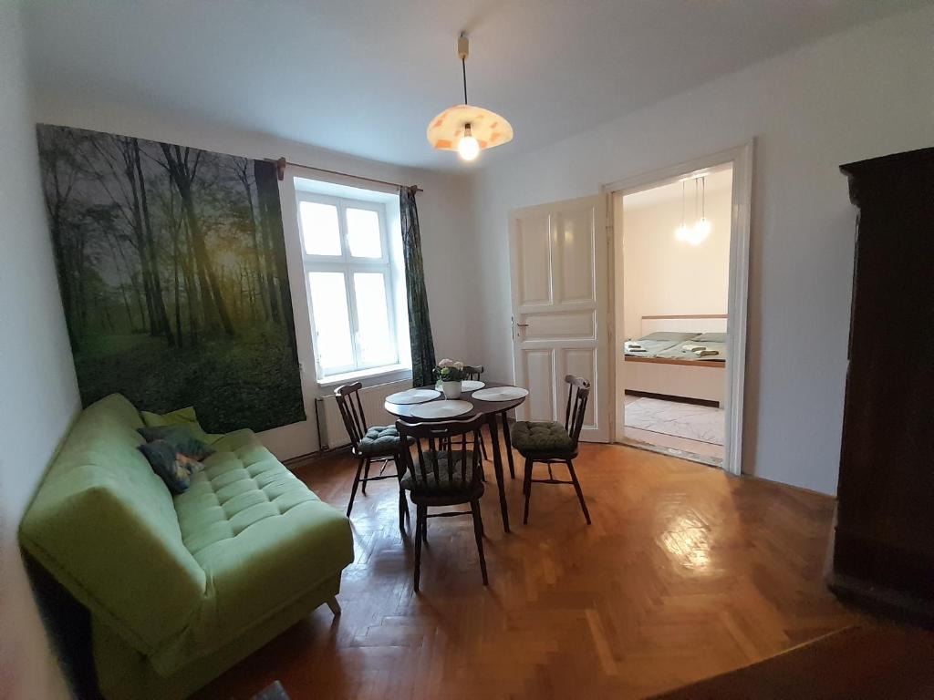 ein Wohnzimmer mit einem grünen Sofa und einem Tisch in der Unterkunft Apartmán Nad náměstím in Liberec
