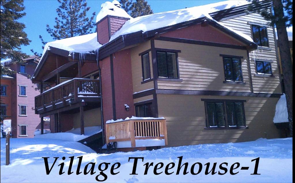 una casa cubierta de nieve con las palabras casa del árbol del pueblo en Village Treehouse #1 en Mammoth Lakes