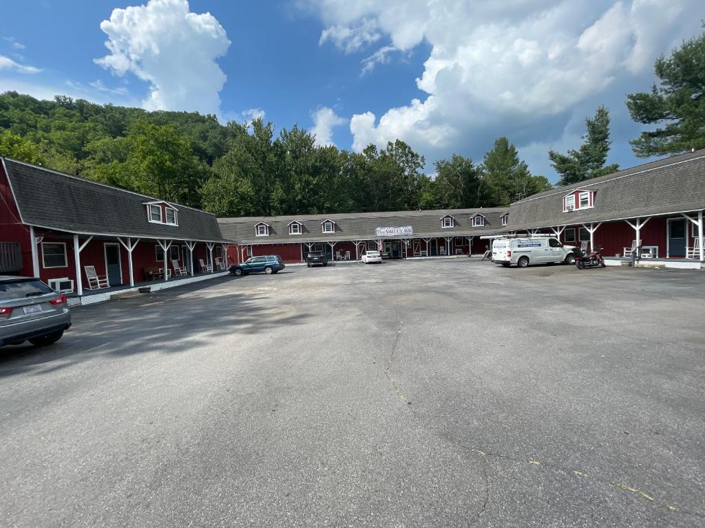a building with cars parked in a parking lot at The Valley Inn in Maggie Valley