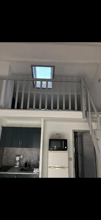 a loft bed in a room with a kitchen at Studio Saint Cyr sur mer in Saint-Cyr-sur-Mer