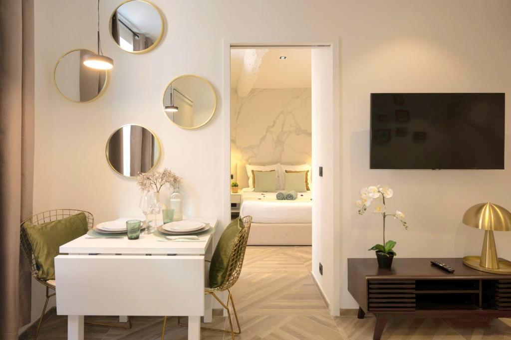 a living room with a white table and a bedroom at Le 34 in Saint-Tropez