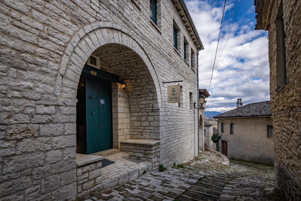 an entrance to a brick building with a green door at Troas Traditional Guesthouse in Vitsa