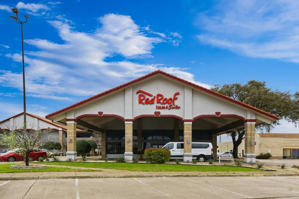 ein Fast-Food-Restaurant mit einem Auto vor dem Hotel in der Unterkunft Red Roof Inn & Suites Irving - DFW Airport South in Irving