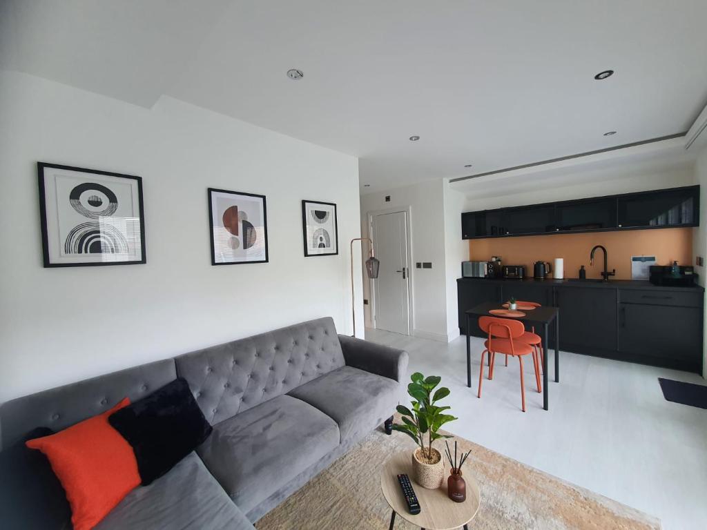 a living room with a gray couch and a table at Stunning 1 King bed cabin in Grays in Grays Thurrock