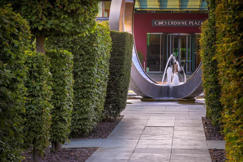 una mujer está parada frente a un edificio en Crowne Plaza Marlow, an IHG Hotel en Marlow