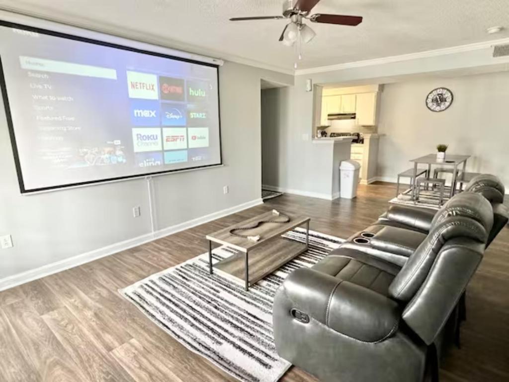 a living room with a couch and a large screen at Home Theater Sleeps 8 WiFi in Morrow