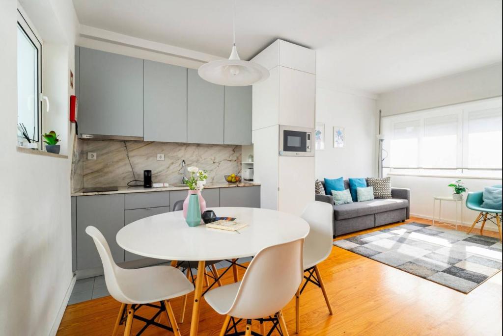 een keuken en woonkamer met een witte tafel en stoelen bij LAZ apartment in Porto