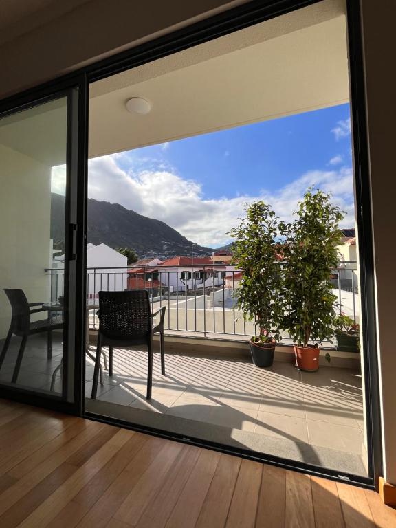 a view from a glass window of a balcony at Apartment Machico near the beach in Machico