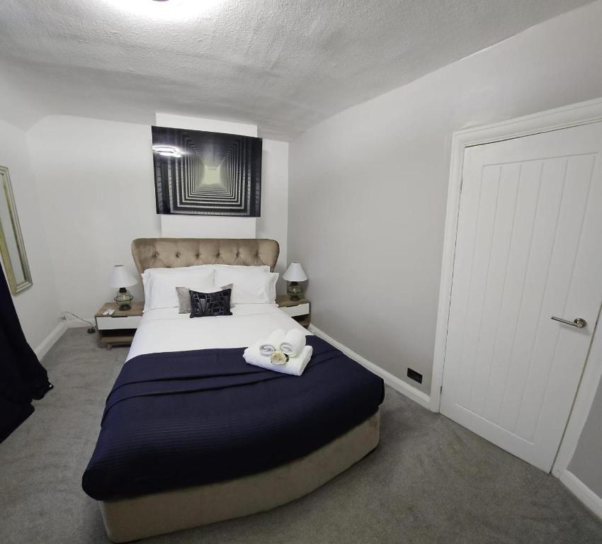Beautiful Home from Home in Manchester في مانشستر: غرفة نوم بسرير كبير مع بطانية زرقاء