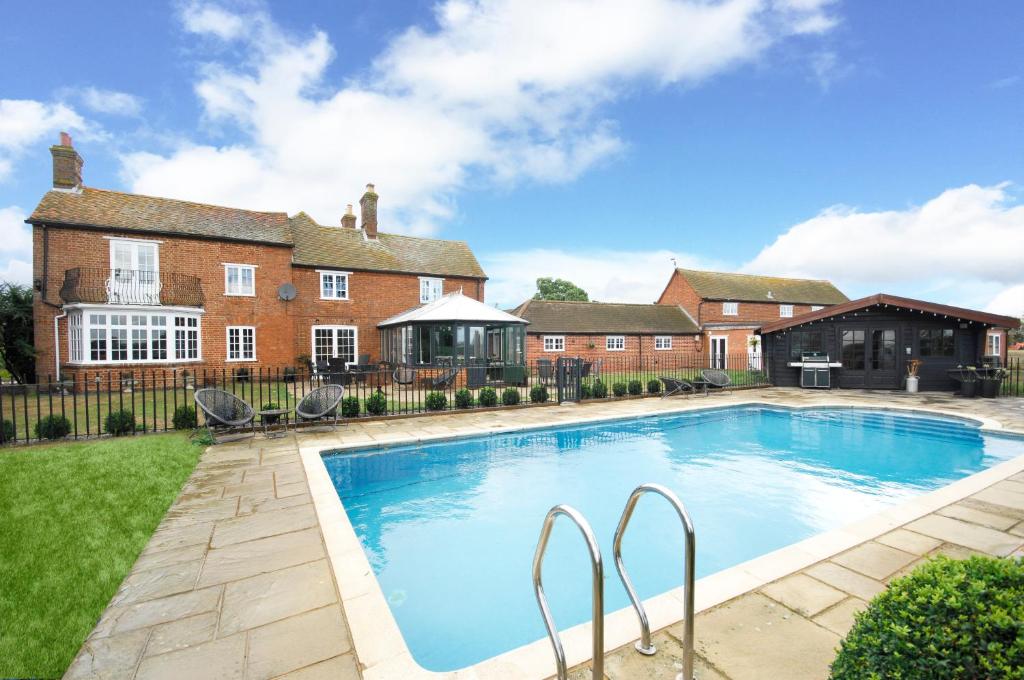 a large swimming pool in front of a house at Warren Farm Farmhouse nr Oxford in Culham