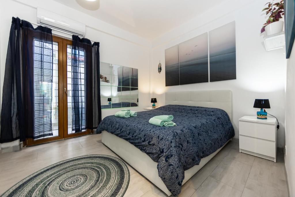 um quarto com uma cama grande e uma janela grande em Lotus - Apartment sul mare con giardino em Lido di Ostia
