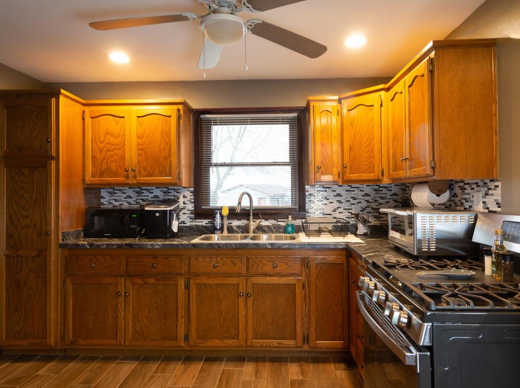 a kitchen with wooden cabinets and a ceiling fan at Near Sundown Mountain and Chestnut Mountain Resorts in Dubuque