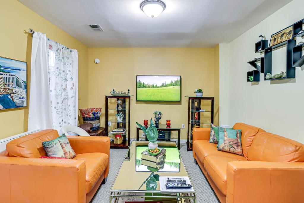 a living room with orange couches and a tv at Cozy Centreville Apt Close to Historic Sites in Centreville